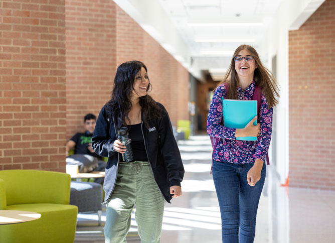 Two Oakton students walking and laughing.