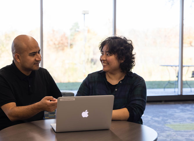 An Oakton College staff member speaking with a student on campus.