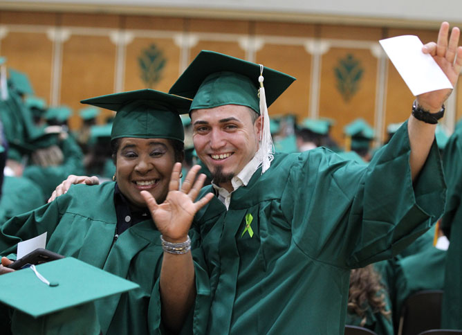  Oakton College students celebrate graduating in full regalia.