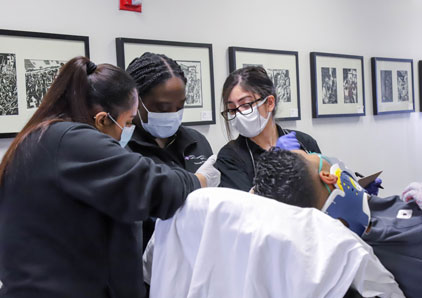 Paramedic students practicing on a mannequin.